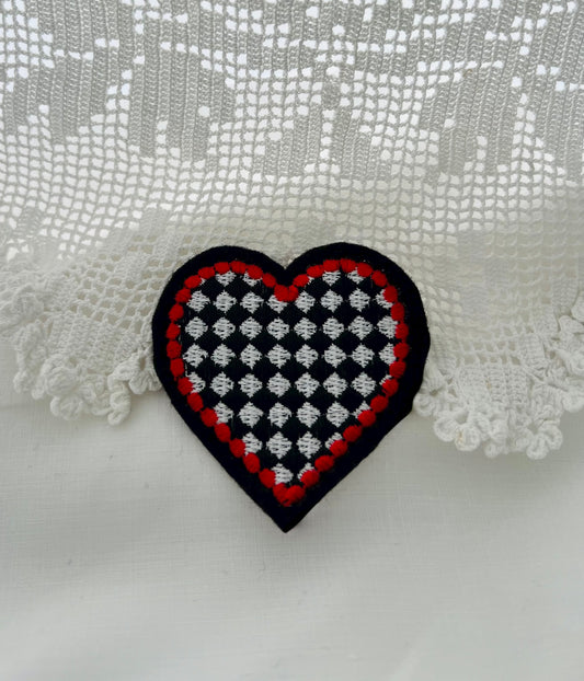 Black & white chequered heart patch with red edging. To be stitched onto your favourite garment.